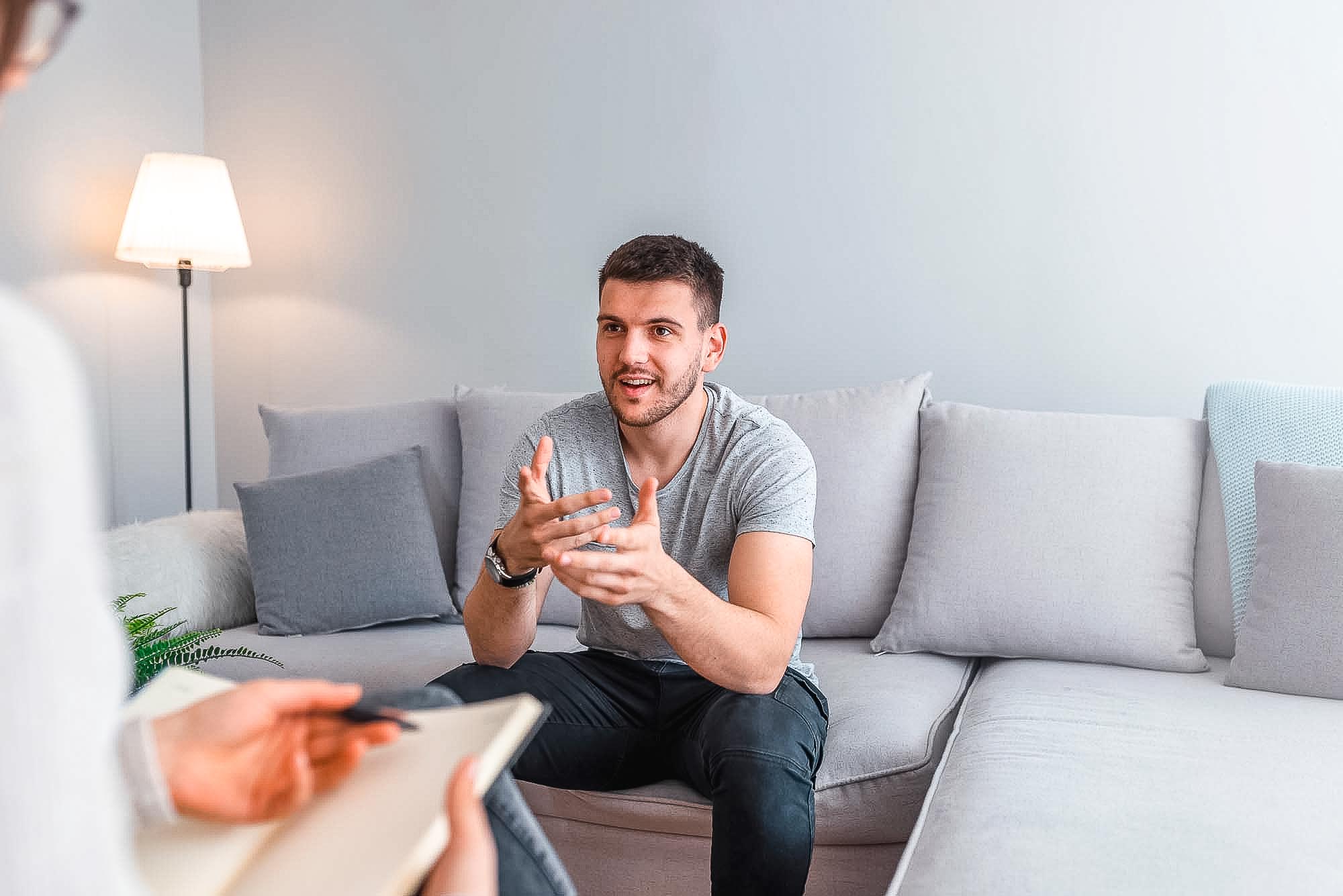 Psychologist talking with happy man in the office. Image of youn