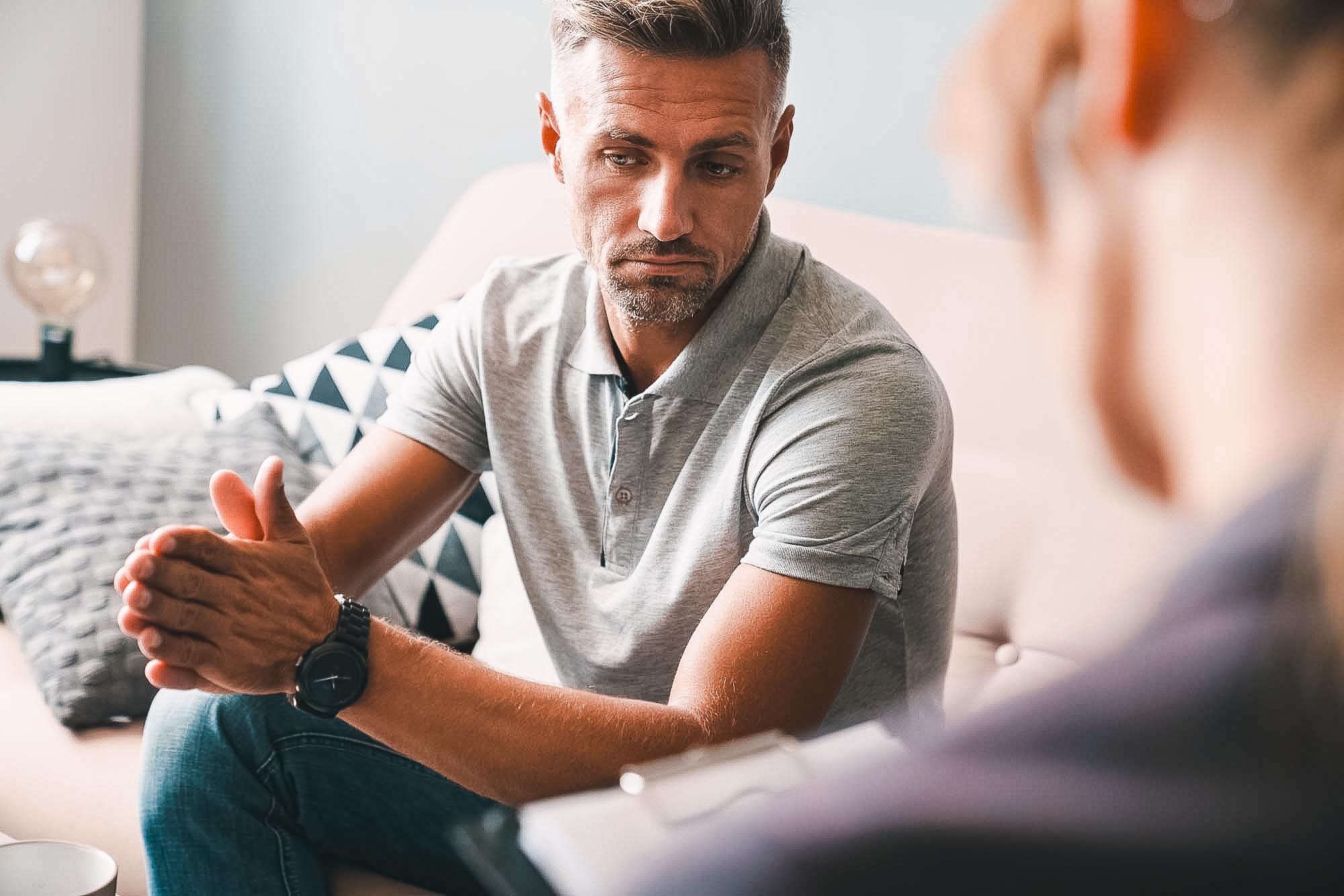 Photo of brooding unshaven man having conversation with psycholo
